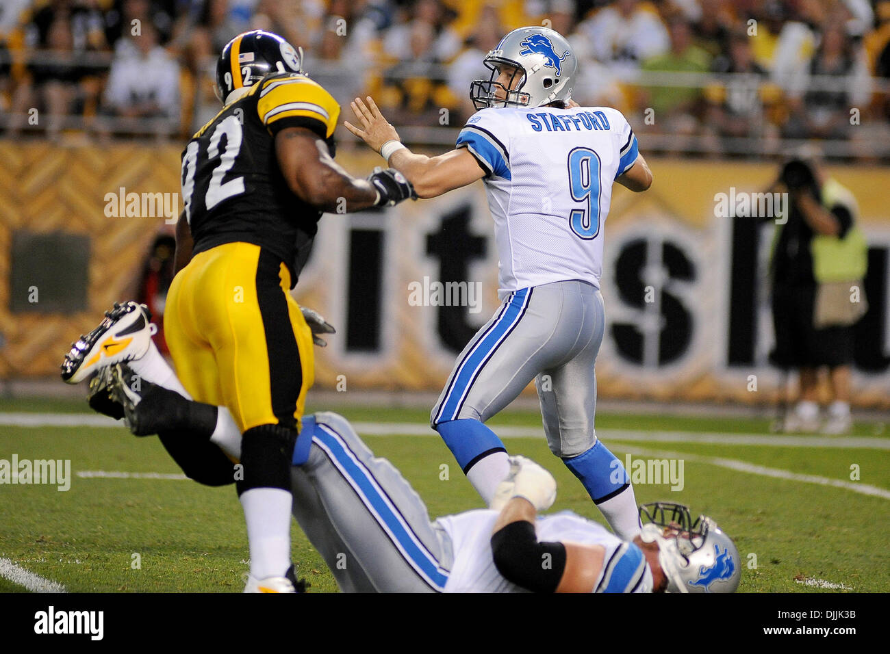 14 agosto 2010 - Pittsburgh, PENNSYLVANNIA, Stati Uniti d'America - 14 August, 2010: Detroit Lions' affrontare JEFF BACKUS (76) Viaggi Pittsburgh Steelers' offensiva linebacker JAMES HARRISON (92) come Detroit Lions' quarterback MATTHEW STAFFORD (9) passi indietro per effettuare il passaggio nel primo trimestre come Pittsburgh Steelers prendere a Detroit Lions nella loro prima pre-stagione partita del Foto Stock