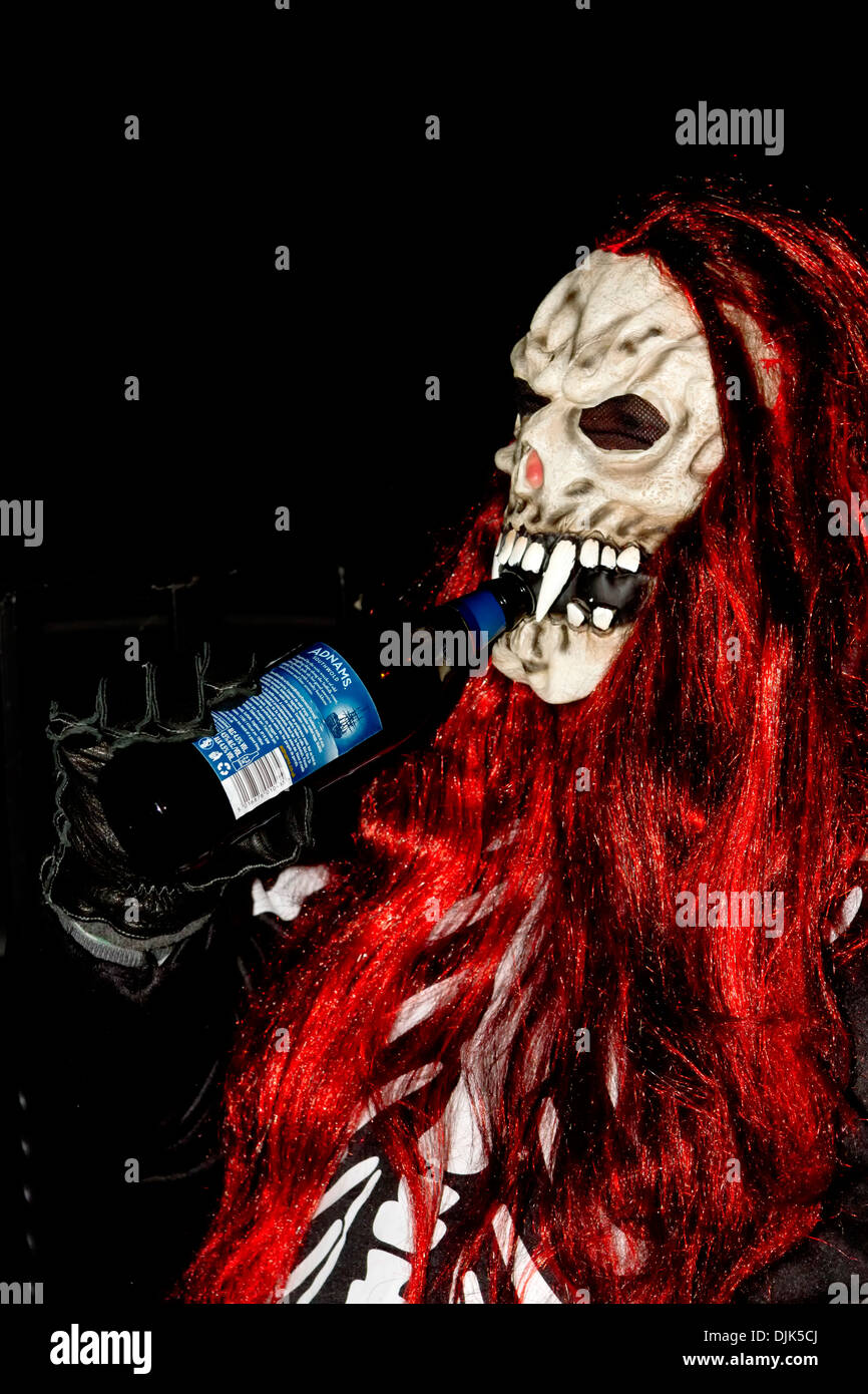 Uomo in Halloween costume scheletro di bere birra da una bottiglia Foto Stock