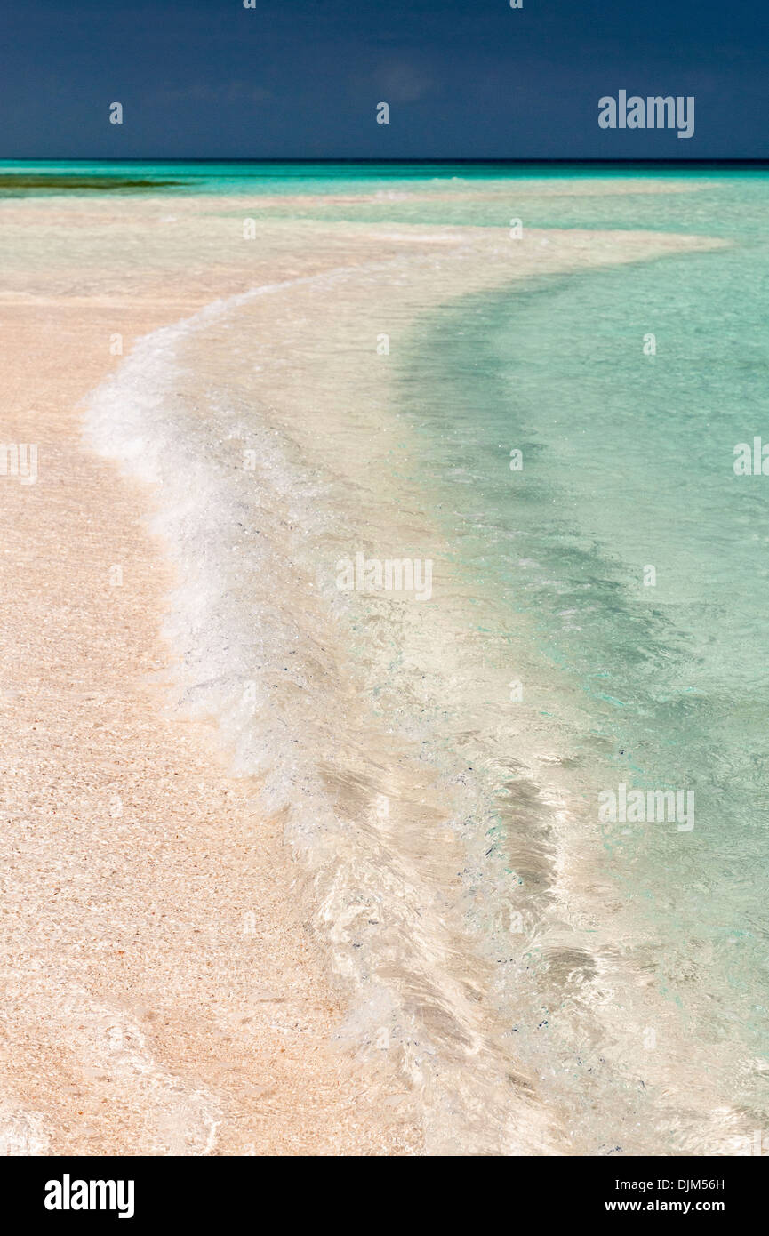 La luce del sole sulle onde che si infrangono sulla sabbia vuoto spit all'estremità meridionale dell'Isola Huon, vicino acqua bassa. Huon Atoll, Nuova Caledonia Foto Stock