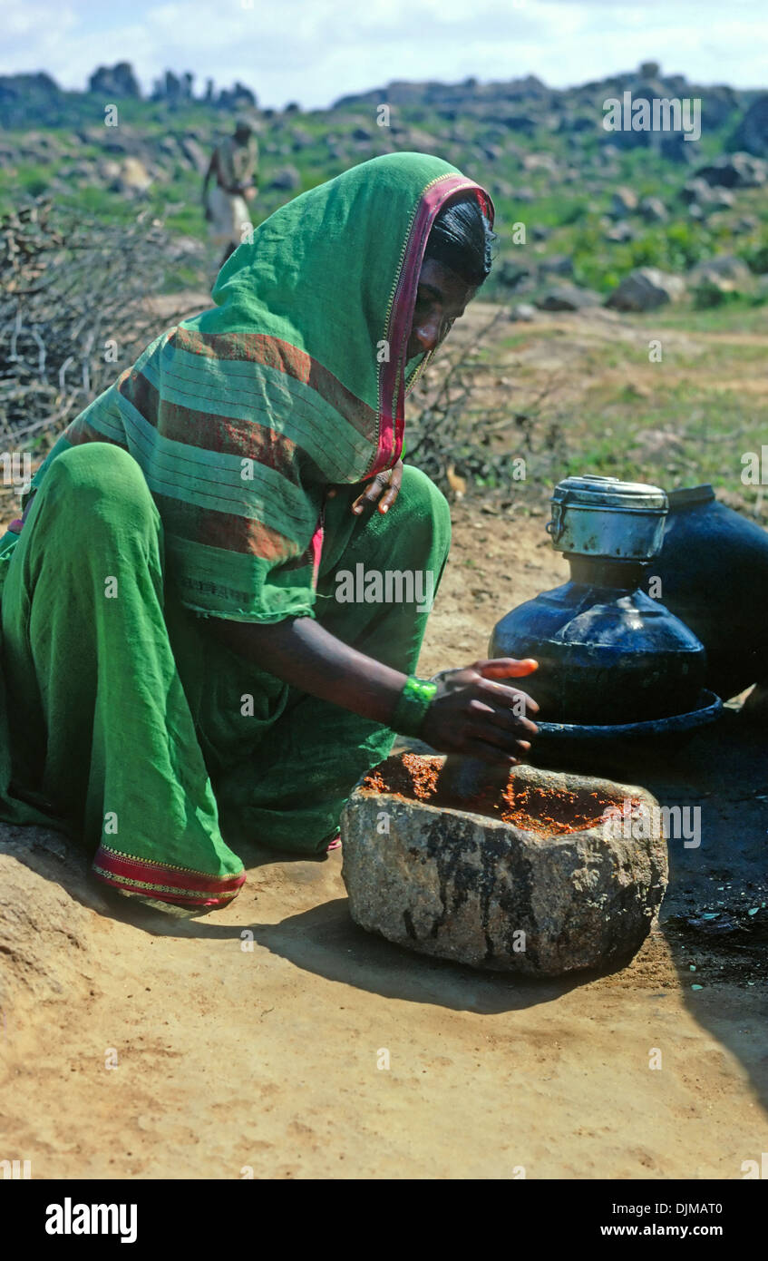 La donna la macinazione con mortaio e pestello di Hyderabad, India Foto Stock