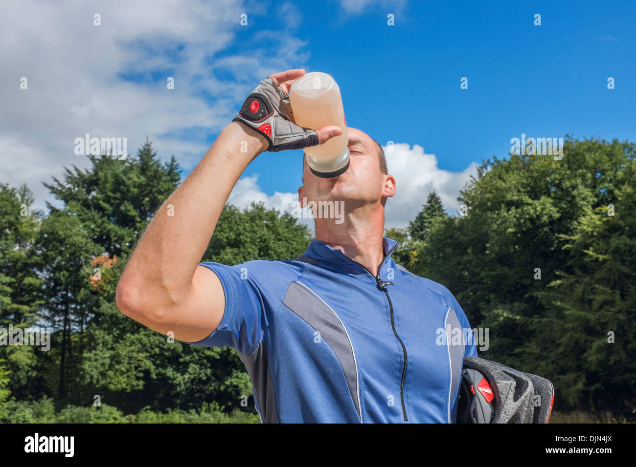 Ciclista maschio bere da una bottiglia di acqua. Foto Stock