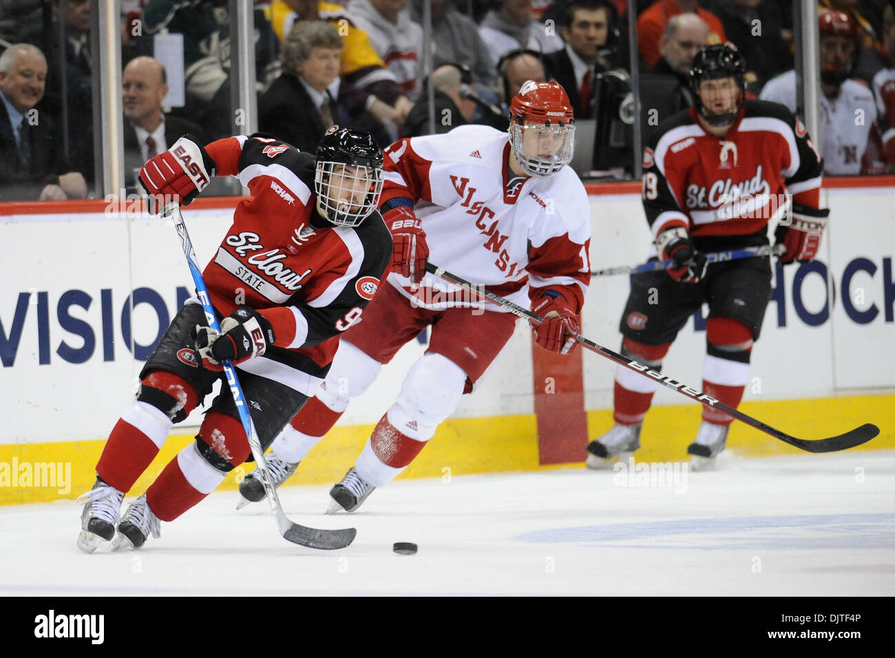 Garrett Roe #9 del St. Cloud membro Huskies prende il puck nella zona neutrale seguita da Andy Bohmbach #11 del Wisconsin Badgers durante il primo periodo presso l'Xcel Energy Center di St Paul, Minnesota. Il badgers sconfitto il Huskies 5-3 per avanzare alla NCAA quattro congelati. (Credito Immagine: © Marilyn Indahl/Southcreek globale/ZUMApress.com) Foto Stock