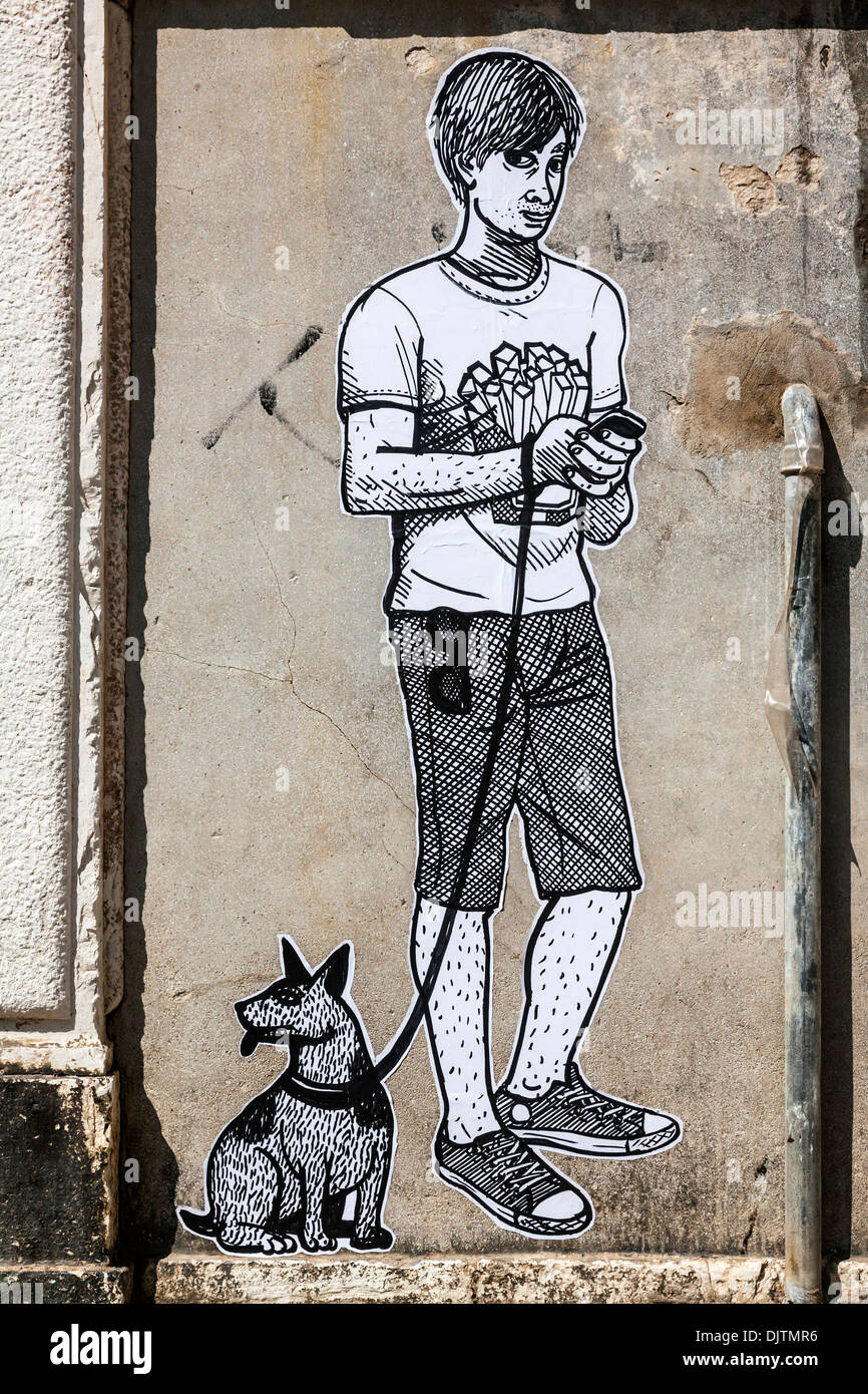 Graffiti cartoon di un ragazzo con un telefono cellulare mentre fuori con il suo cane, Venezia, Italia. Foto Stock