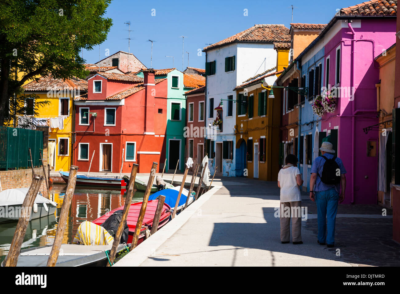 Giovane camminando lungo da un canale sulla isola di Burano, Veneto, Italia. Foto Stock