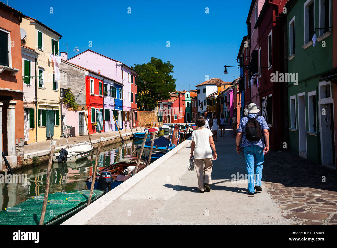 Giovane camminando lungo da un canale sulla isola di Burano, Veneto, Italia. Foto Stock