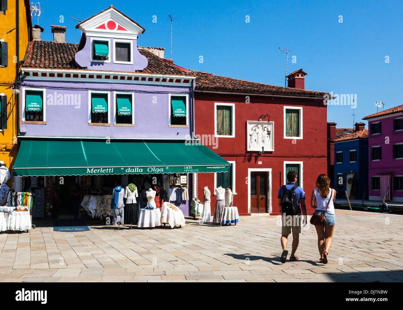 Giovane camminando attraverso le strade di Burano, Venezia, Veneto, Italia. Foto Stock