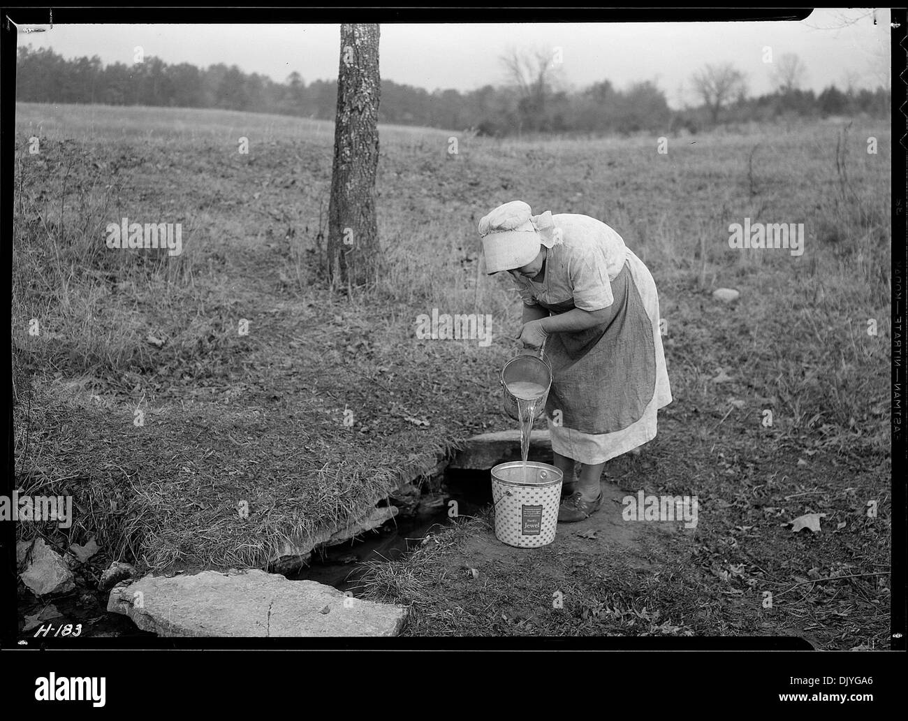 La signora Wallace è mostrata immergere l'acqua da una sorgente in una fattoria vicino al sito della città di Norris, che è stata recentemente acquisita dalla Tennessee Valley Authority (TVA) per un progetto agricolo sperimentale. Il TVA mirava a esplorare nuovi metodi agricoli e lo sviluppo della comunità. Foto Stock