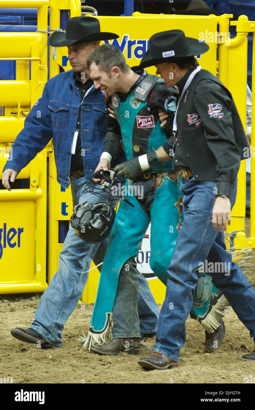 Dicembre 2, 2010 - Las Vegas, Nevada, Stati Uniti d'America - Bull rider D.J. Domangue di Houma, LA è aiutato fuori dell'arena dopo riding gatto nero durante il primo go-round a 2010 Wrangler National Finals Rodeo al Thomas & Mack Center. (Credito Immagine: © Matt Cohen/Southcreek globale/ZUMAPRESS.com) Foto Stock