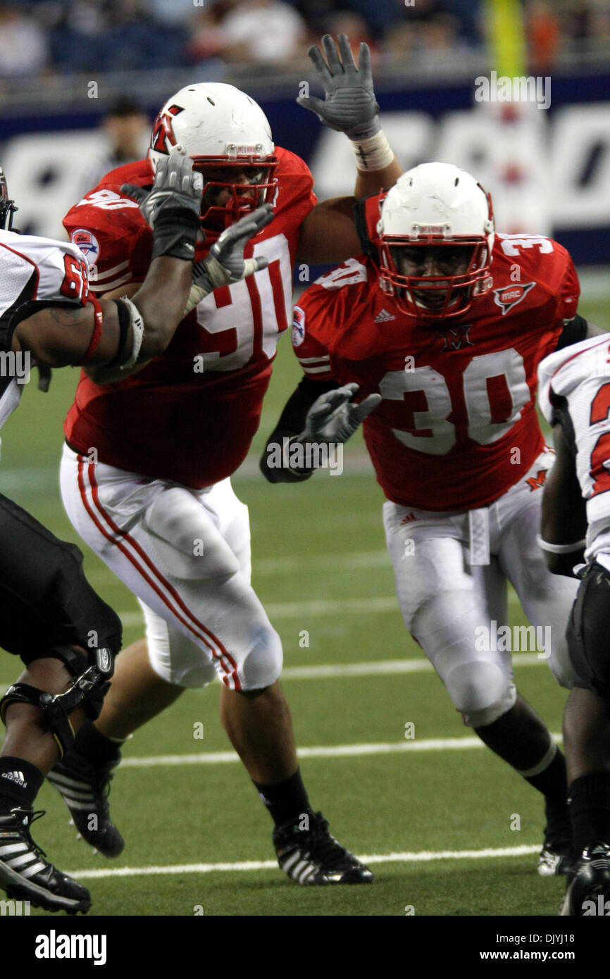 Dicembre 3, 2010 - Detroit, Michigan, Stati Uniti d'America - Miami defensive lineman Austin marrone (#90) e linebacker Evan Harris (#30) passo attraverso una fessura nel backfield offensivo. Miami sconfitto Northern Illinois 26-21, vincendo il Campionato del MAC. (Credito Immagine: © Alan Ashley/Southcreek globale/ZUMAPRESS.com) Foto Stock