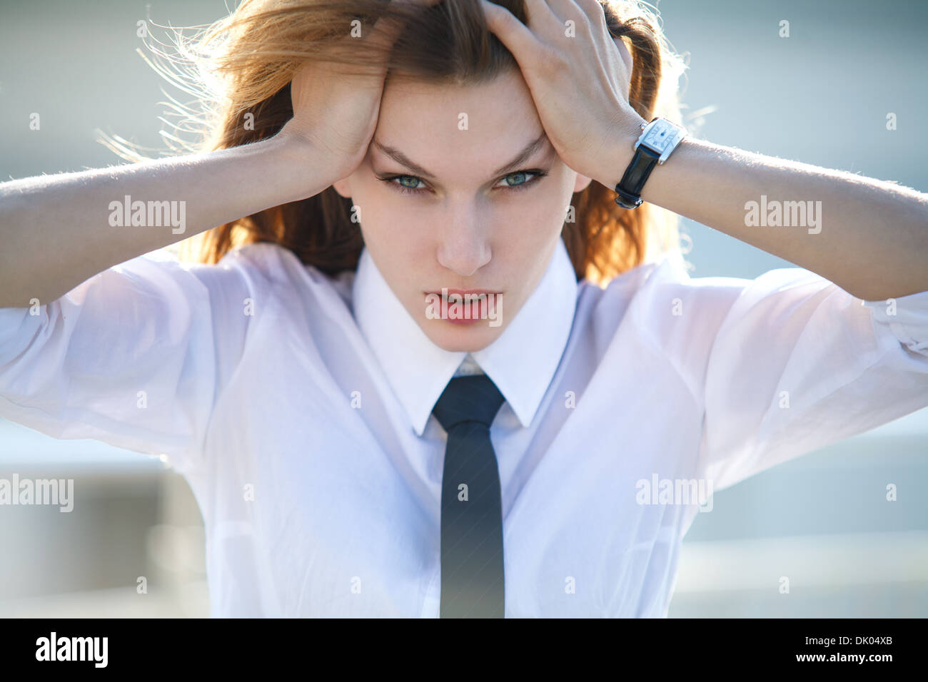 Addolorato giovane donna mantiene la sua testa con entrambe le mani Foto Stock