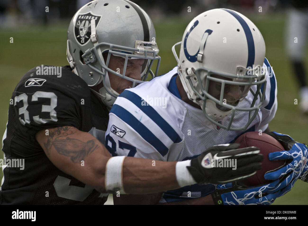 Dic. 26, 2010 - Oakland, CA, Stati Uniti d'America - Oakland Raiders vs Indianapolis Colts a Oakland-Alameda County Coliseum Domenica, 26 dicembre 2010. Oakland Raiders sicurezza ramo Tyvon #33 affronta Indianapolis Colts wide receiver Reggie Wayne #87 dopo che egli le catture pass..Raiders allentati per Colts 26 a 31 (Credito Immagine: © Al Golub/ZUMAPRESS.com) Foto Stock