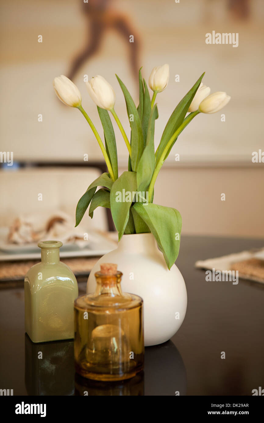 White tulipani in vaso sul tavolo da pranzo Foto Stock