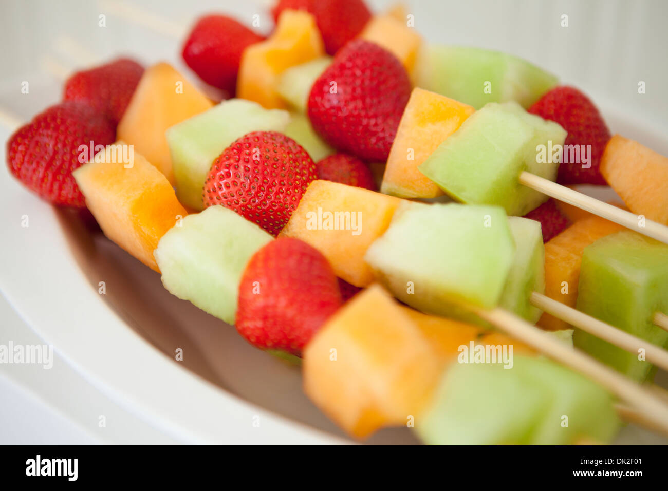 Close up di fragola, melone e melone Honeydew e spiedini di frutta Foto Stock