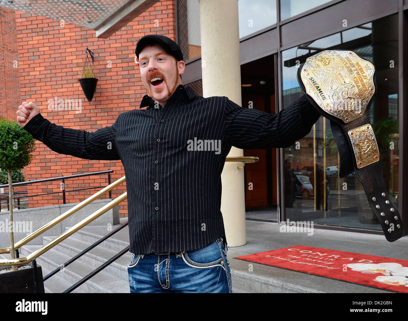 Grappler irlandese Sheamus mette in mostra il suo nuovo WWE World Heavyweight title sui passi del suo hotel prima di dirigervi a WWE Smackdown visualizza Foto Stock