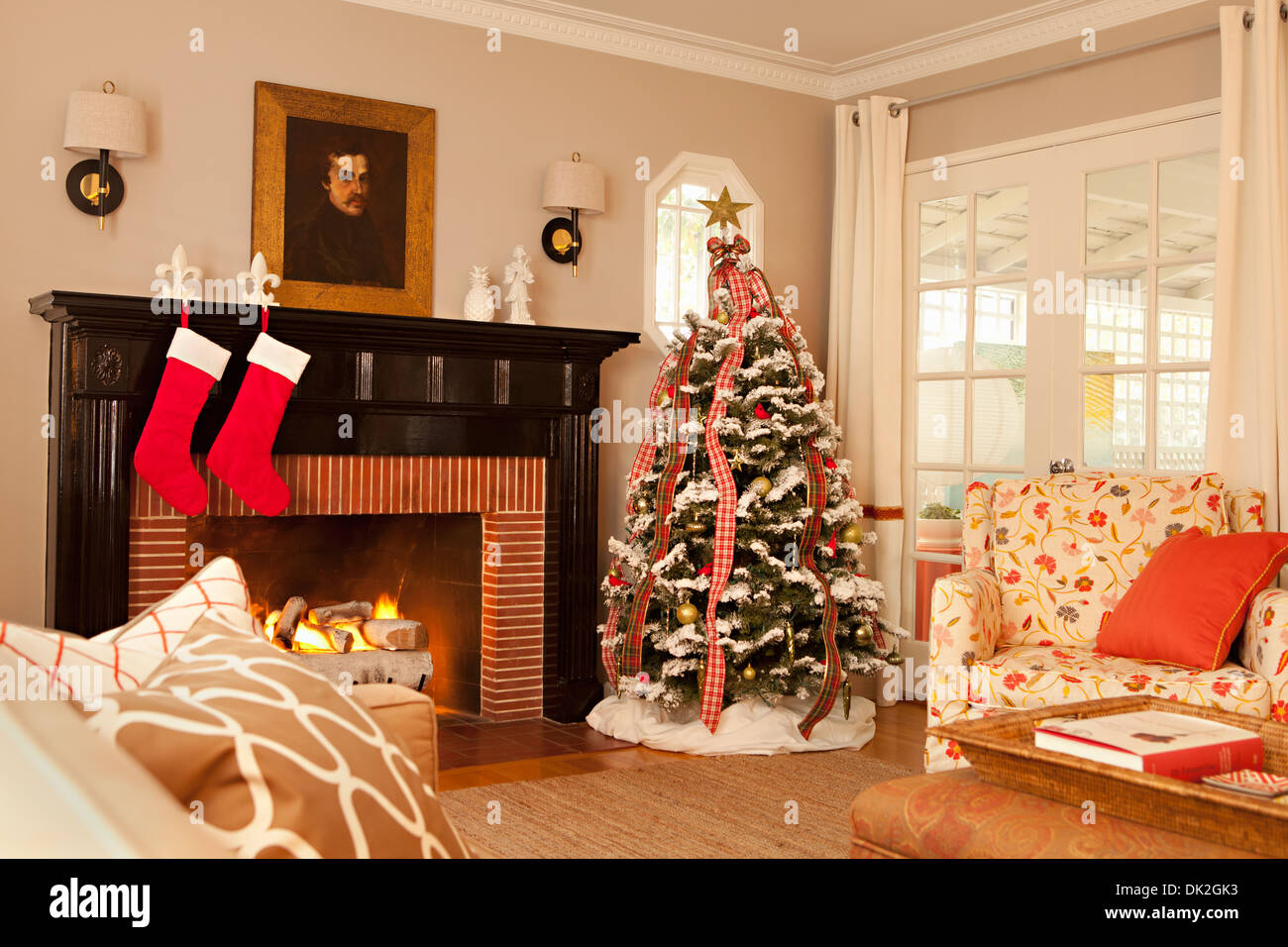 Elegante soggiorno con camino decorato con albero di Natale e calze appeso Fleur de Lis titolari Foto Stock