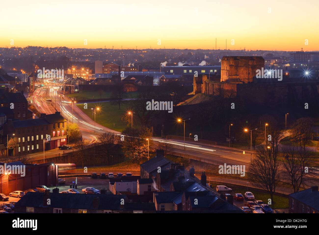 Un giallo tramonto dietro il Castello di Carlisle city centre Foto Stock