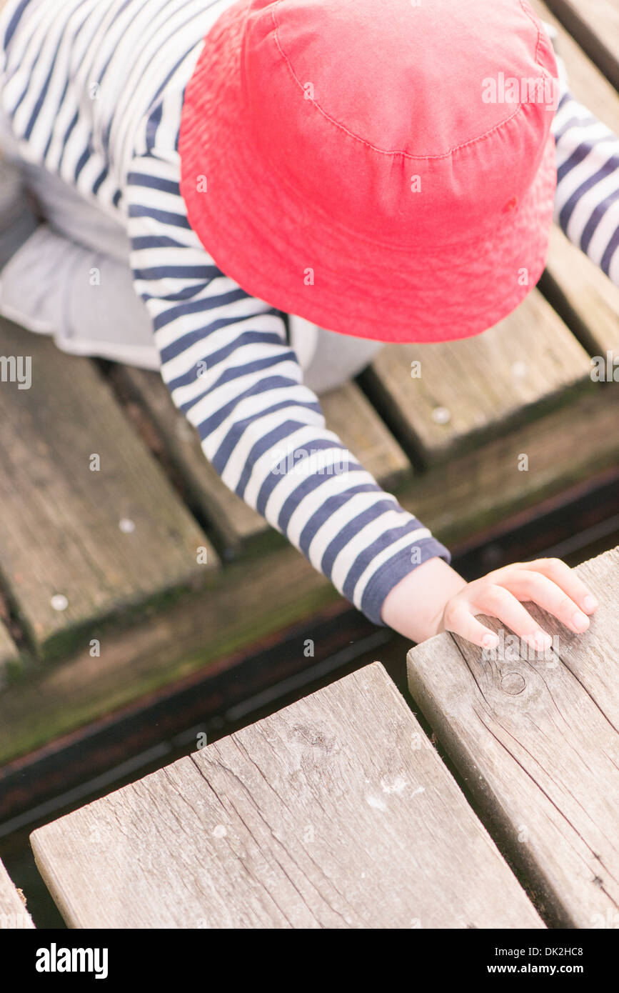 Stile di vita momento di estate infanzia. Bambina gioca su jetty, Svezia Foto Stock