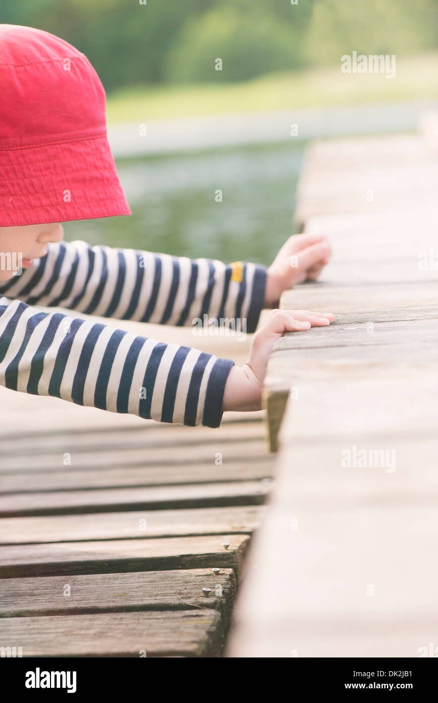 Stile di vita momento di estate infanzia. Bambina gioca su jetty, Svezia Foto Stock