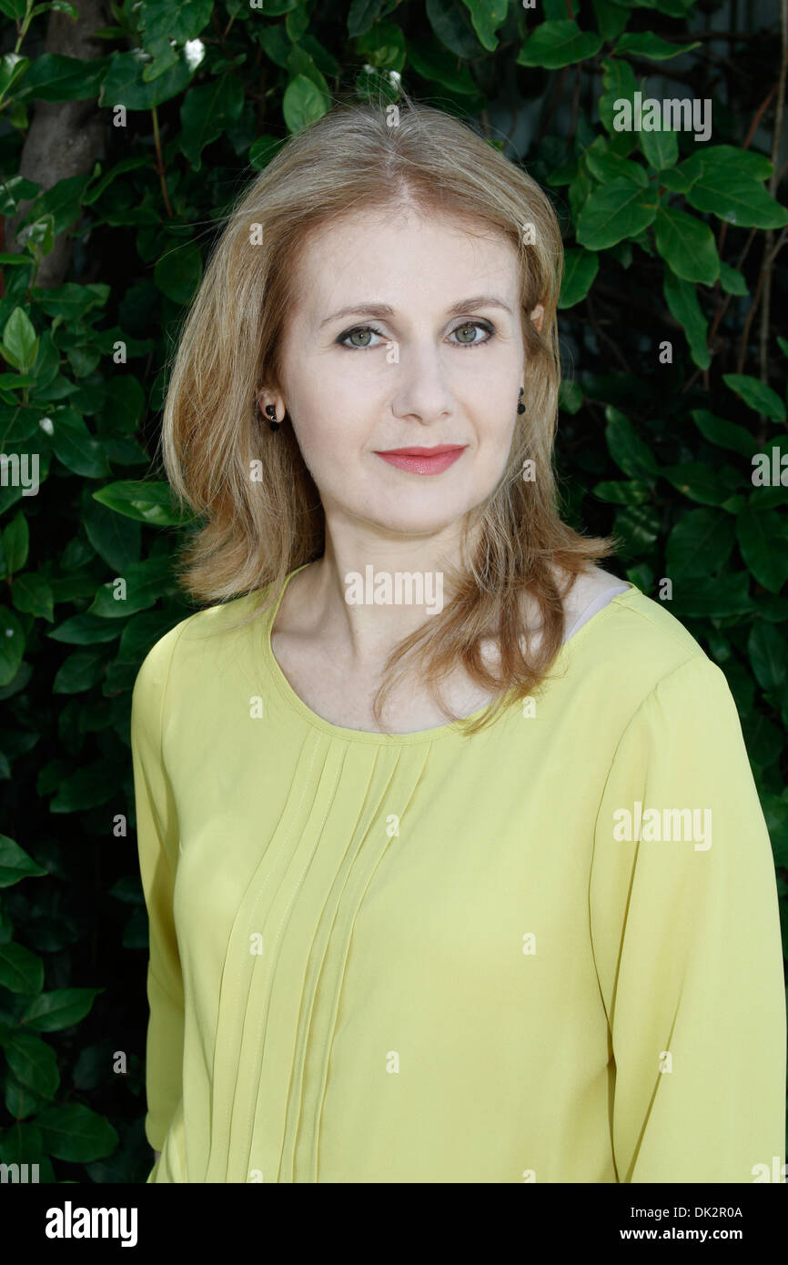 Donna di mezza età con foglie di colore verde Foto Stock