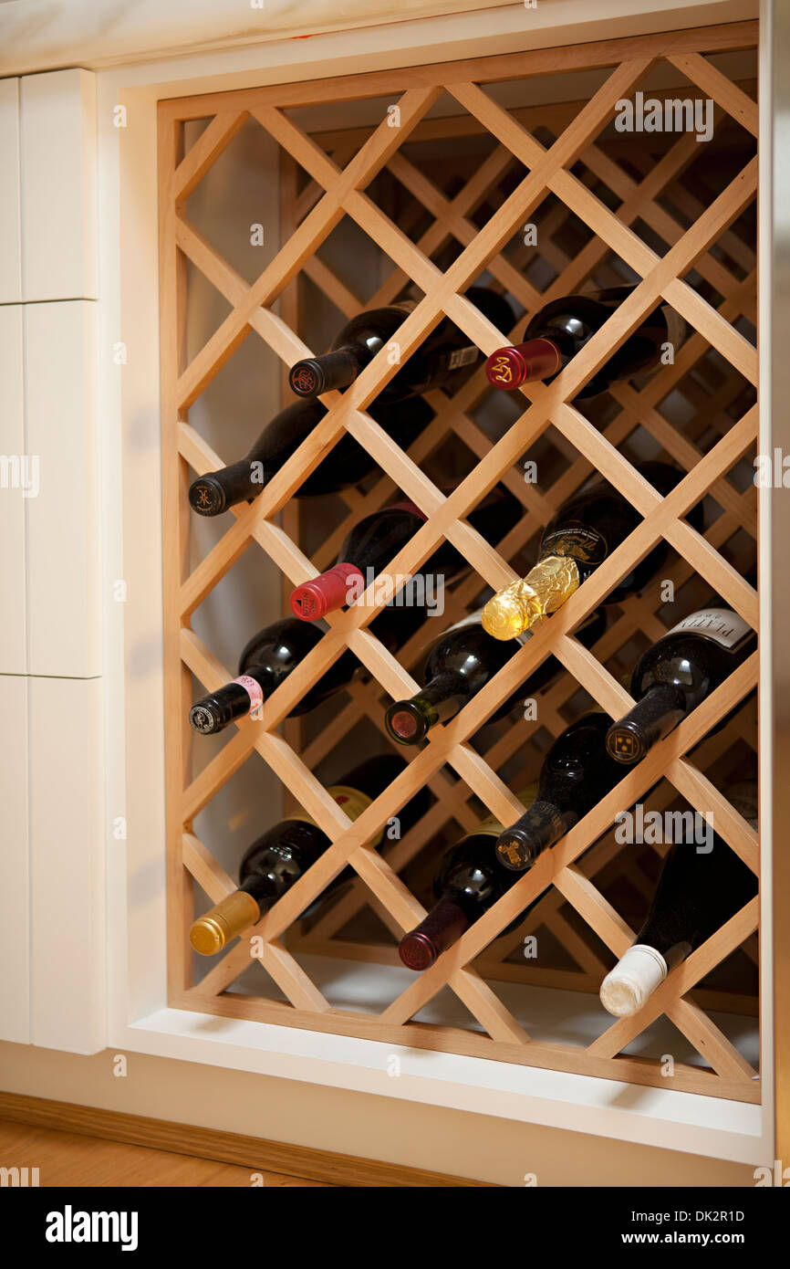 Le bottiglie di vino in built-in legno rack di vino Foto Stock
