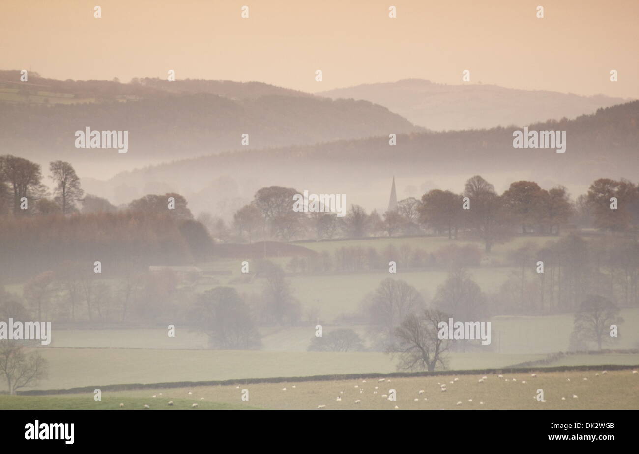 Foschia mattutina nel Peak District, Derbyshire affacciato sul villaggio di Edensor sul Chatsworth Station Wagon Foto Stock