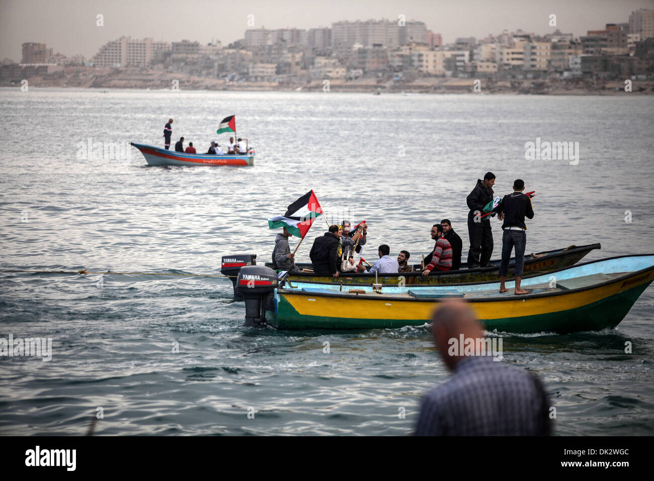 La striscia di Gaza, Territori palestinesi, . 2° dic, 2013. I palestinesi di una barca come una bandiera nazionale oscilla durante una manifestazione di protesta contro il blocco su Gaza, al porto di Gaza City il 2 dicembre 2013. Israele ha imposto un blocco sulla striscia di Gaza nel 2007 dopo il gruppo islamista Hamas ha assunto il controllo del territorio in una breve guerra civile con Western-backed il presidente palestinese Mahmoud Abbas del partito Fatah.Foto: Majdi Fathi/NurPhoto Credito: Majdi Fathi/NurPhoto/ZUMAPRESS.com/Alamy Live News Foto Stock