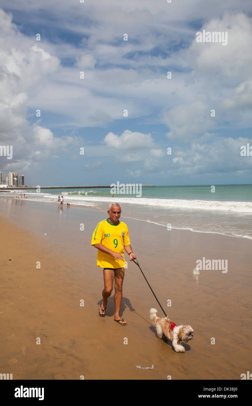 Uomo che cammina alla spiaggia Praia do Meireles, Fortaleza, Brasile. Foto Stock