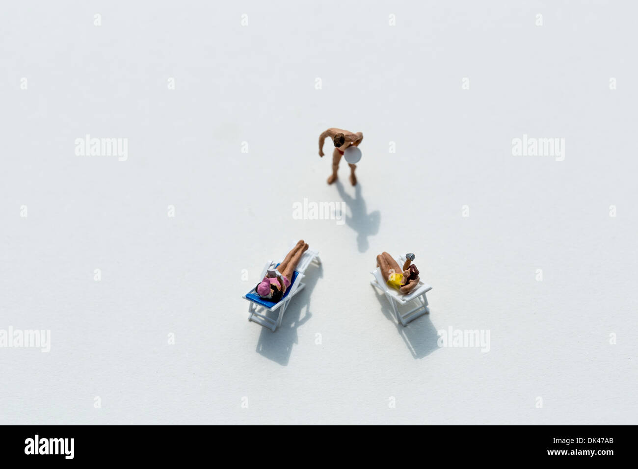 Figurine su uno sfondo bianco socializzare presso il beach club Foto Stock