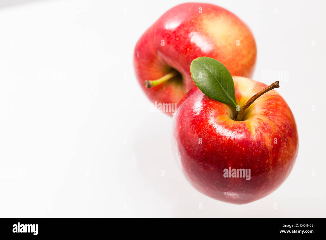 Due mele rosse sulla superficie di vetro Foto Stock