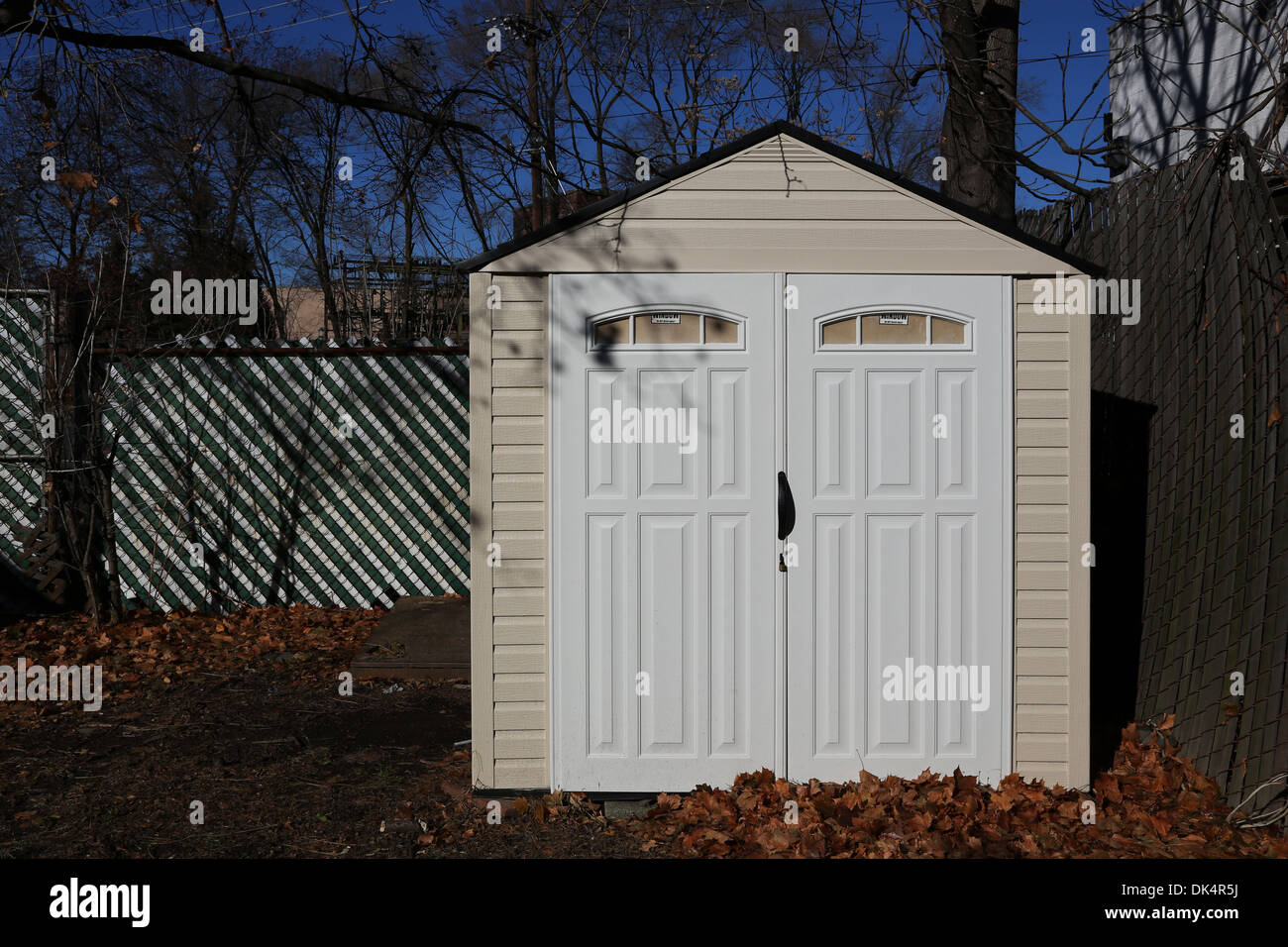 Capannone per il rimessaggio presso il cortile con le foglie sul terreno Foto Stock