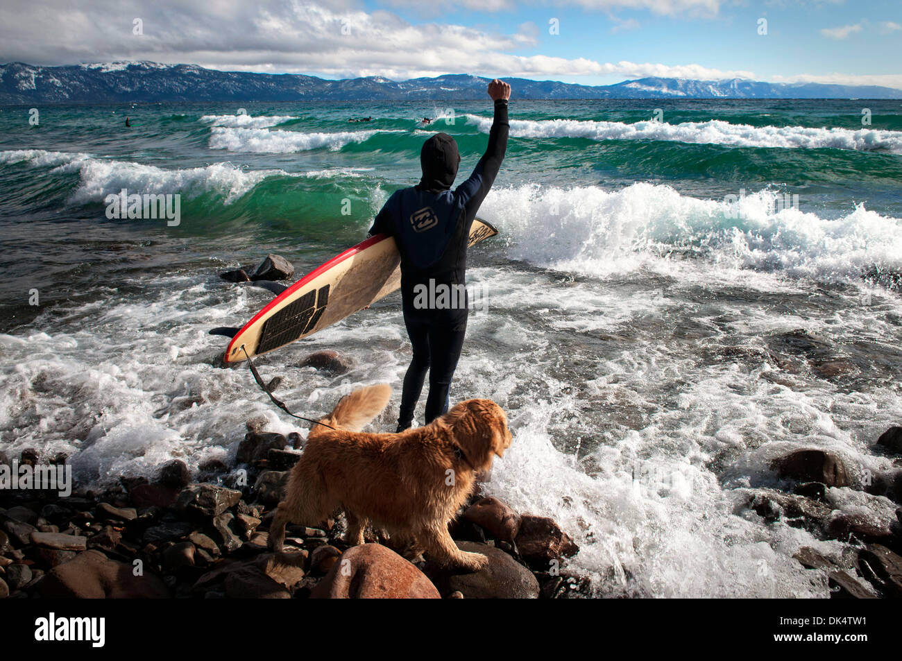 Febbraio 14, 2011 - Lake Tahoe, CA, Stati Uniti d'America - un surfista cheers suoi amici su come essi prendere l'onda...Surfers prendere le onde del lago Tahoe durante una forte tempesta di vento che precedono una tempesta di neve che si sta muovendo a. Le onde prodotte dai forti venti sono cavalcato da surfisti e paddleboarders. Il clima invernale richiede i surfisti a pieno indossare abbigliamento protettivo per proteggerli da frig Foto Stock