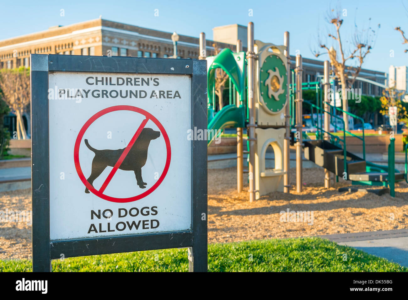 Segno che vieta i cani in corrispondenza di una zona giochi per bambini. Foto Stock