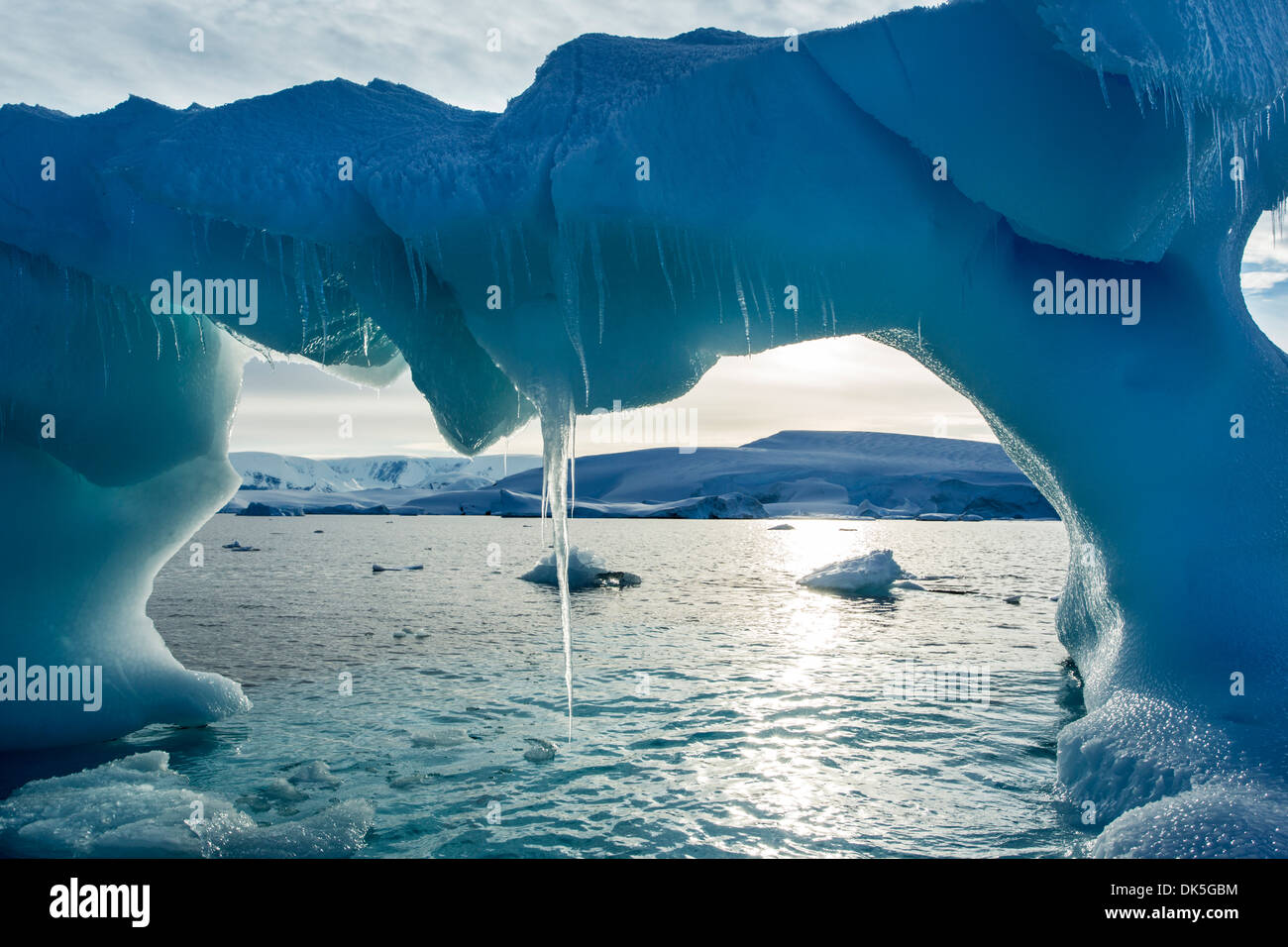 L'Antartide, ghiaccioli pendono dai arcuata di iceberg vicino a galleggiante Enterprise isola in Wilhelmina Bay lungo la penisola antartica all'alba Foto Stock