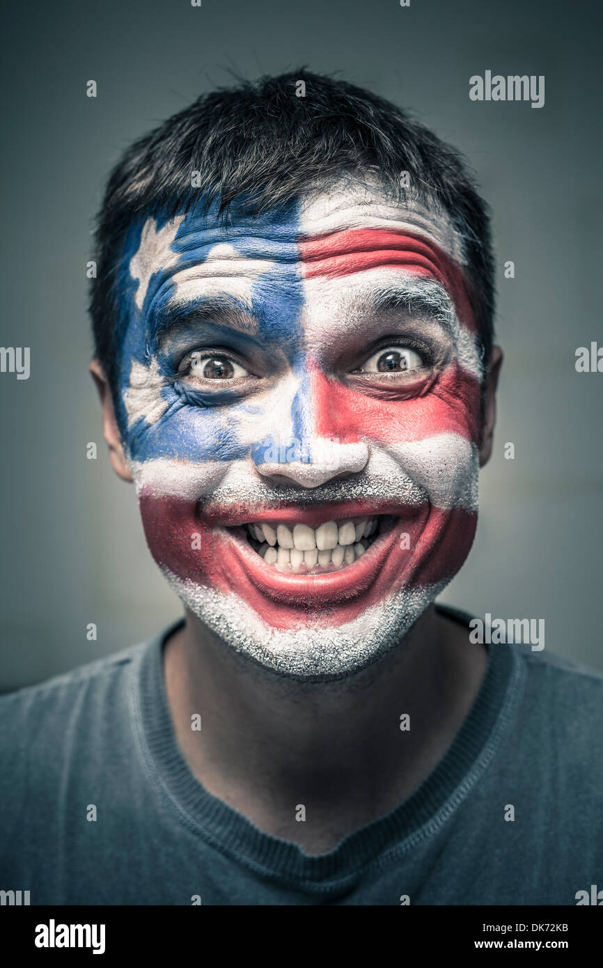Ritratto di funny toothy uomo sorridente con noi bandiera dipinto sul volto. Foto Stock