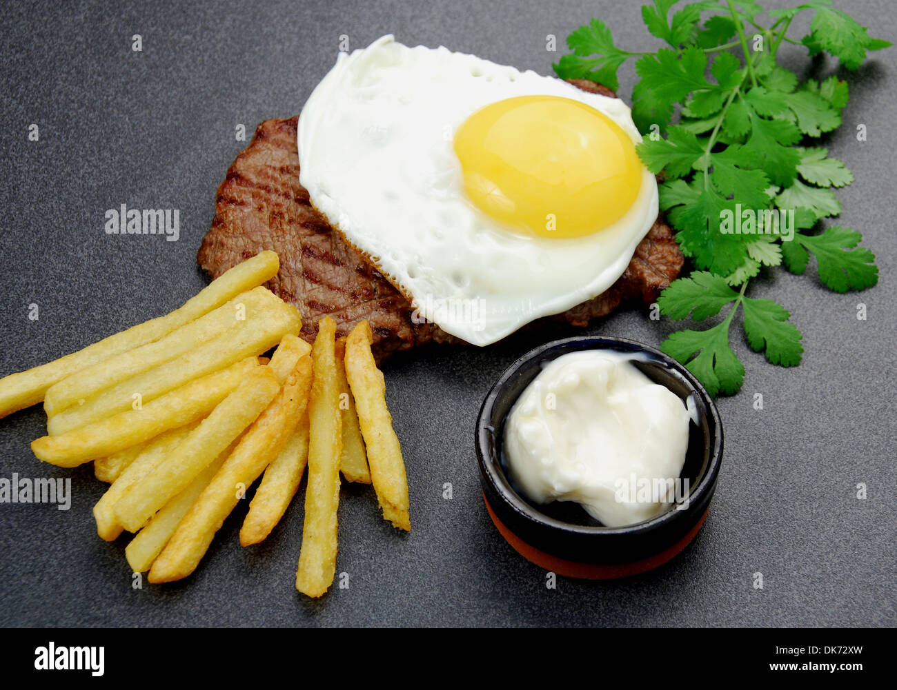 Lucky bistecca. Sandwich Scamone bistecca e rabboccato con un intervallo libero uovo fritto, un lato di patatine fritte e mayo. Foto Stock