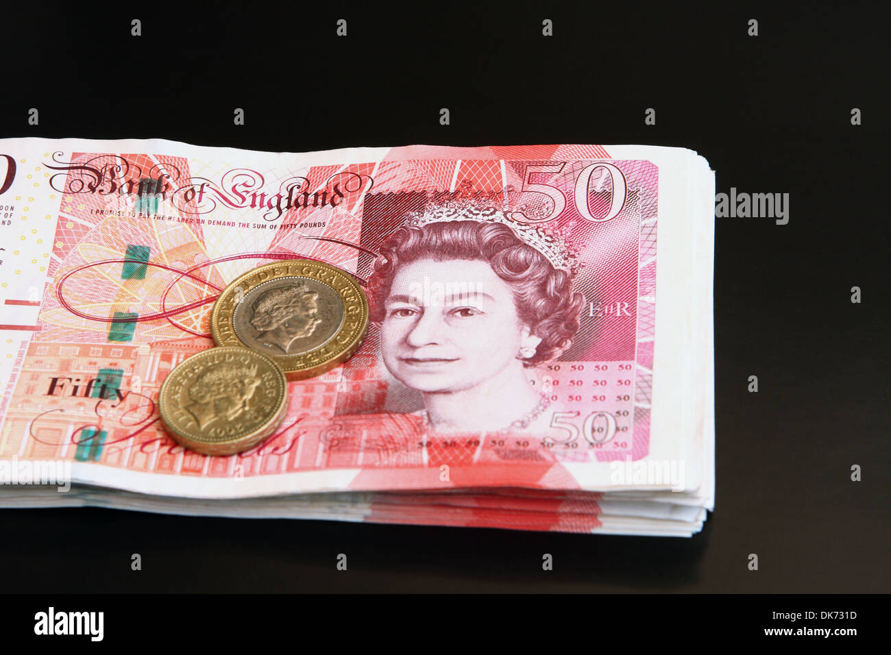 Sterling £2 e £1 moneta di una pila di £50 note Foto Stock