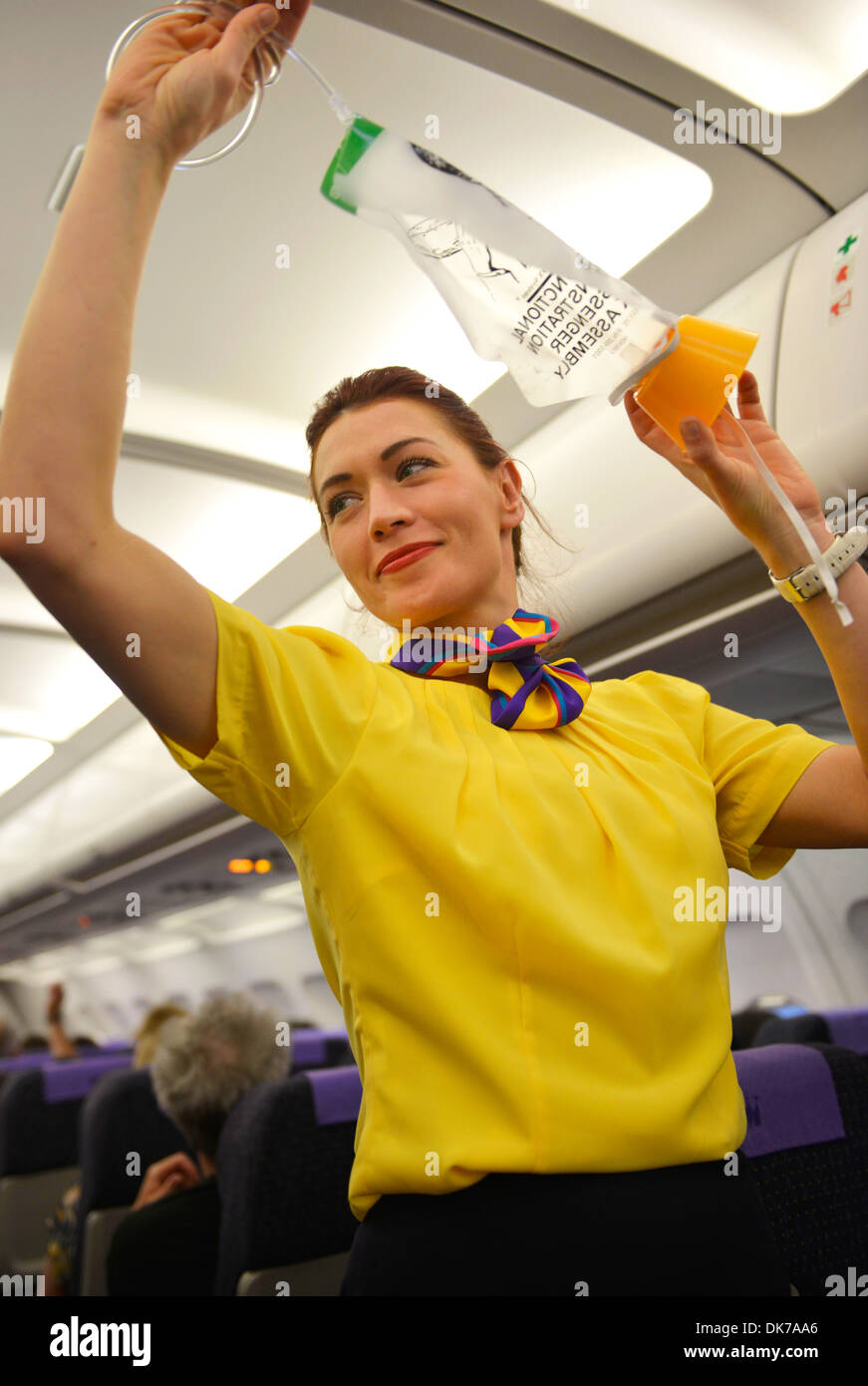 Aria steward spiega le procedure di sicurezza per i passeggeri di un aereo commerciale prima della partenza, hostess procedura di sicurezza Foto Stock