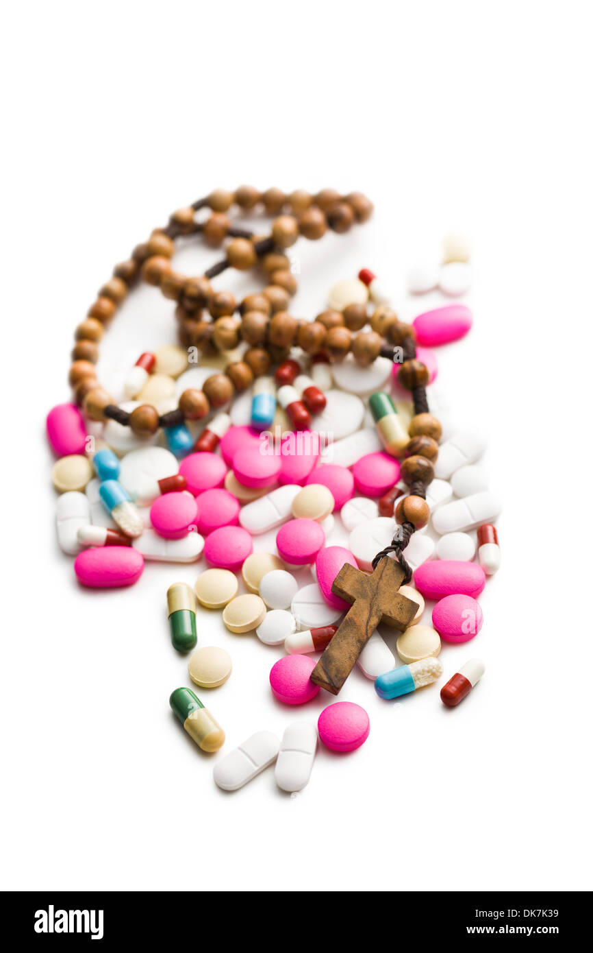 Pillole colorate con i grani del rosario su sfondo bianco Foto Stock