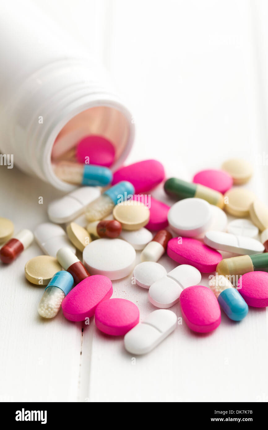 Pillole colorate spillato dal flacone di medico Foto Stock
