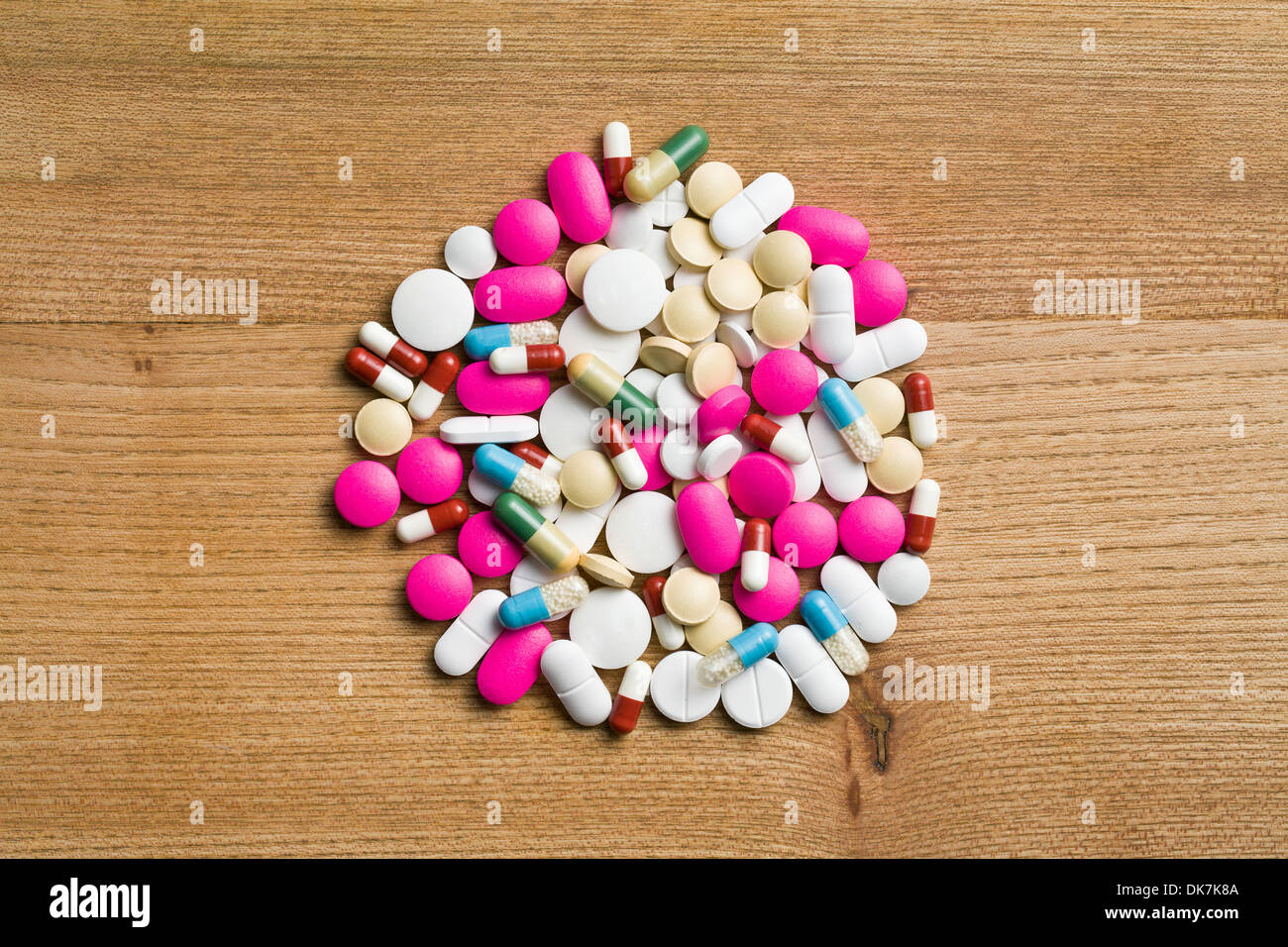 Vista dall'alto di pillole colorate su sfondo di legno Foto Stock