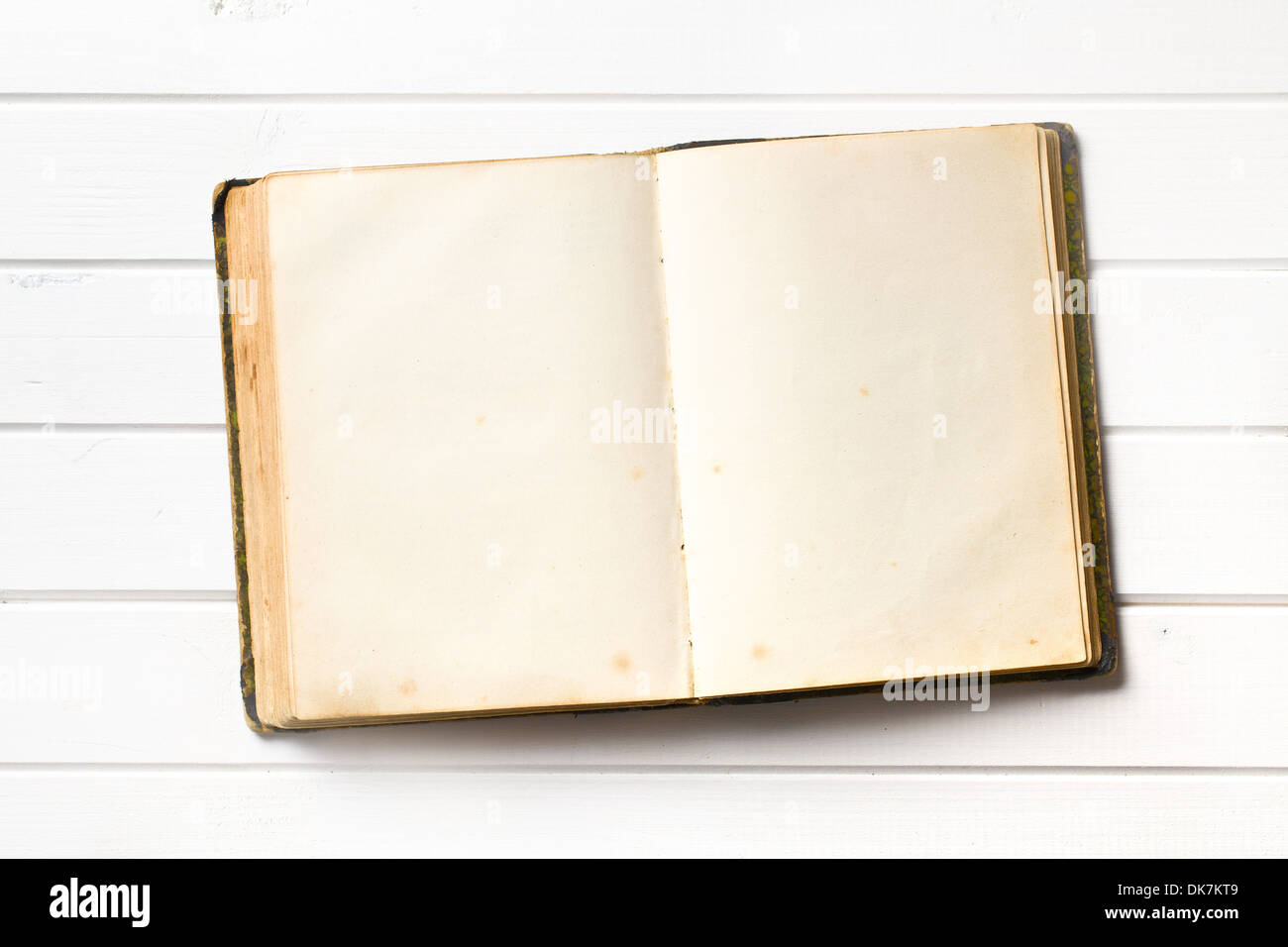 Vista superiore del vecchio libro aperto sul bianco sullo sfondo di legno Foto Stock