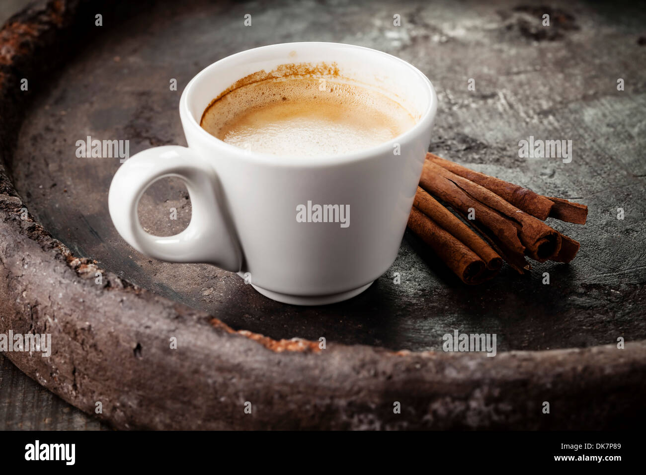 Tazza da caffè con bastoncini di cannella su sfondo scuro Foto Stock