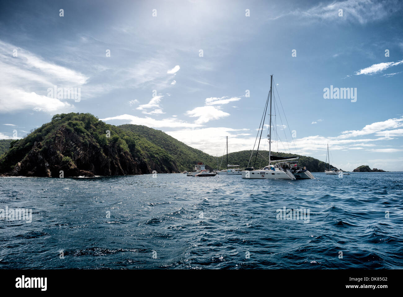 L'ancoraggio alle grotte a Norman Island nelle Isole Vergini Britanniche. Il sito è un popolare punto di snorkeling, con tre grotte accessibili dall'acqua. Norman Island è reputata l'ispirazione per il romanzo Treasure Island di Robert Louis Stevenson. Conosciuta per la sua variegata vita marina e le barriere coralline, la regione caraibica vanta alcuni dei paesaggi marini più belli e ben conservati del mondo. Foto Stock