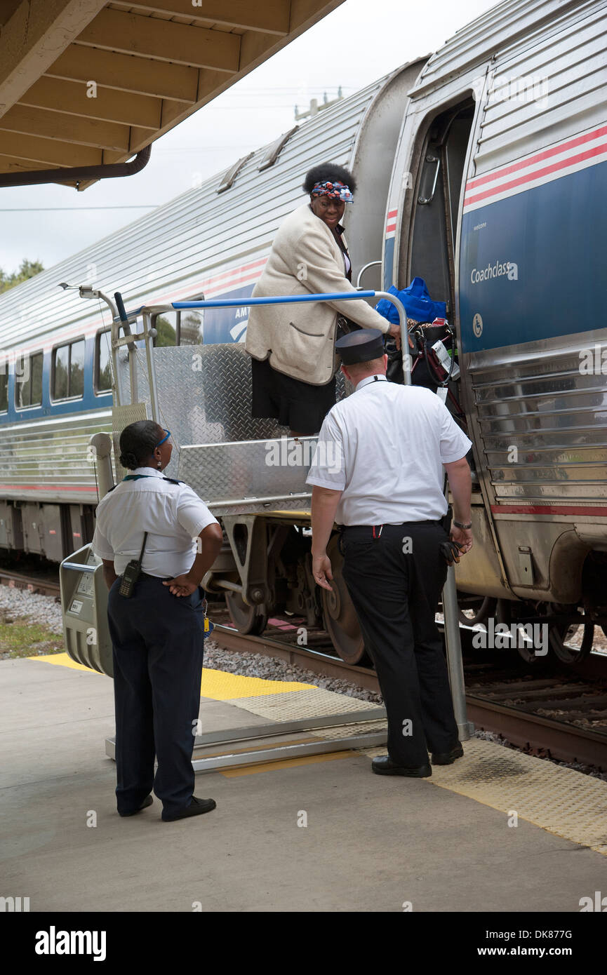 Signora usando un portatile di servoscala a bordo di un treno Amtrak a DeLand Station Florida USA Foto Stock