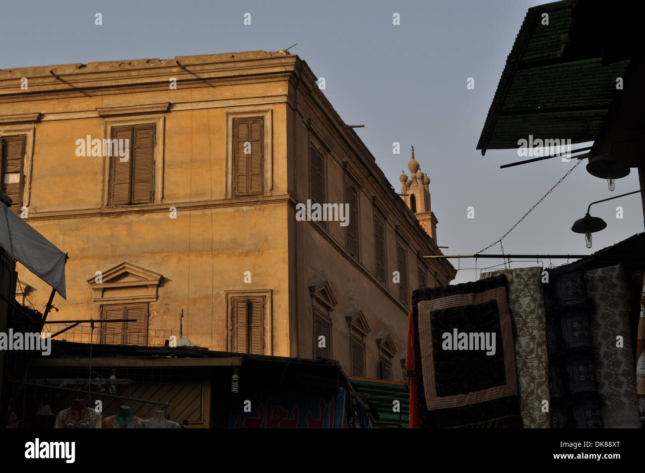 Le merci sono appese in un mercato di fronte a palazzi signorili storici nell'antico quartiere islamico della capitale egiziana il Cairo. Foto Stock