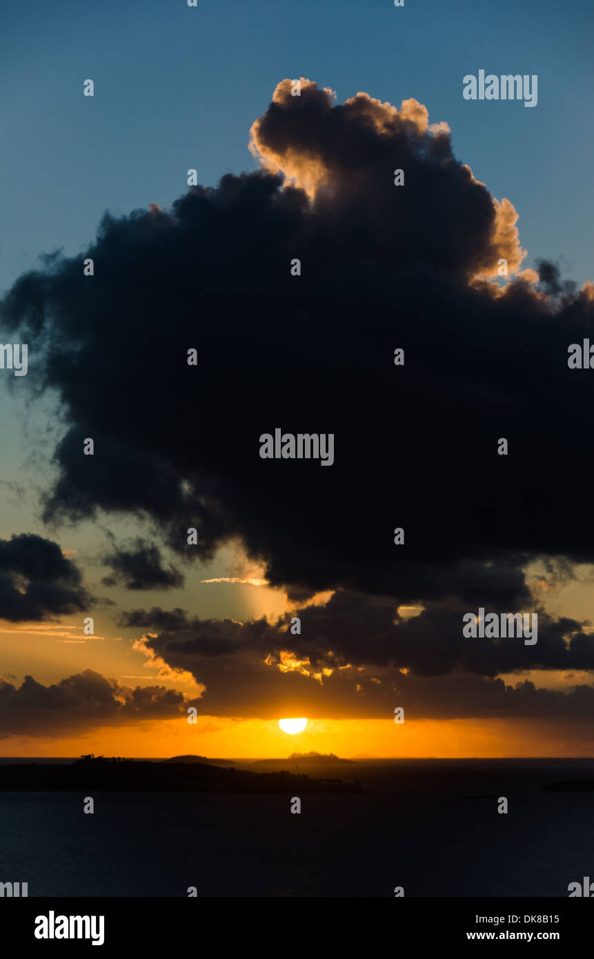 Sun sagome a grandi nuvole appena sopra l'orizzonte durante un bellissimo tramonto dei Caraibi nelle Isole Vergini statunitensi. Foto Stock