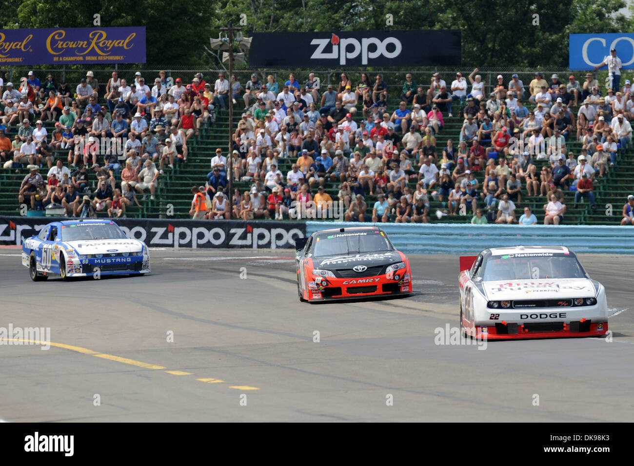 Agosto 13, 2011 - Watkins Glen, New York, Stati Uniti - Kurt Busch, driver del (22) sconto pneumatico/Ruby Tuesday Dodge, conduce Kyle Busch, driver del (18) Z-Line progetta la Toyota e Carl Edwards, driver del (60) Fastenal Ford, attraverso girare un inizio nella mostra Zippo 200 a Watkins Glen International in Watkins Glen, NY. Kurt Busch ha vinto la gara dopo la partenza in pole e conduce 37 giri Foto Stock