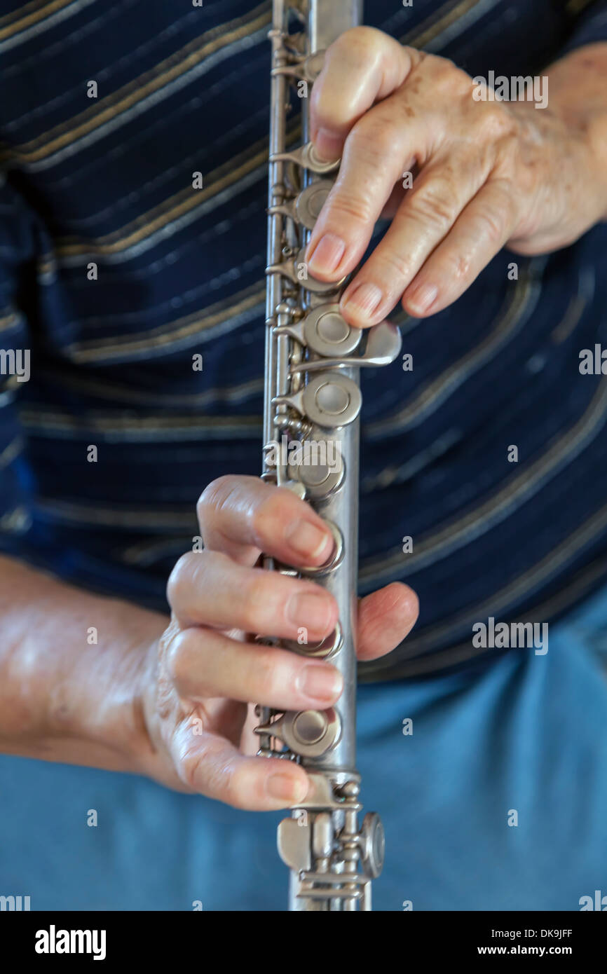 Primo piano delle mani di una matura donna più anziana, parte dei nativi americani, suonare il flauto, STATI UNITI D'AMERICA. Foto Stock