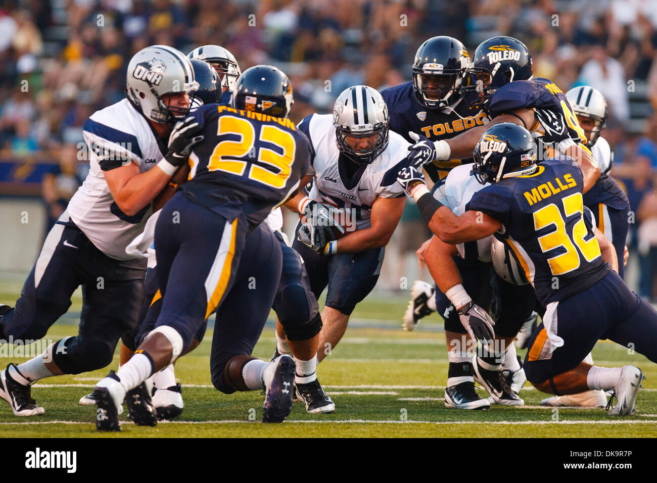 Sett. 1, 2011 - Toledo, Ohio, Stati Uniti - New Hampshire running back Chris Setian (30) scorre attraverso un foro nella linea di scrimmage come Toledo difensivo fine T.J. Fatinikun (23) e linebacker Dan Molls (32) preparare per rendere l'arresto durante il secondo trimestre di azione di gioco. Il Toledo Rockets, della Conferenza Mid-American, sconfitto il New Hampshire Wildcats, del Colonial Athletic Associati Foto Stock