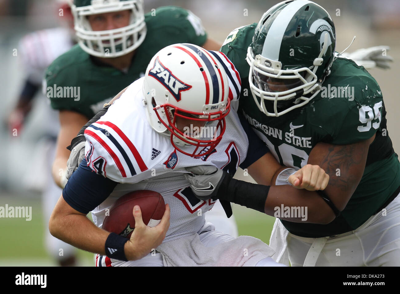 Sett. 10, 2011 - East Lansing, Michigan, Stati Uniti - Florida Atlantic gufi quarterback Graham Wilbert (14) viene saccheggiata dal Michigan State Spartans tackle difensivo Jerel degno (99) (credito Immagine: © Rey Del Rio/Southcreek globale/ZUMAPRESS.com) Foto Stock